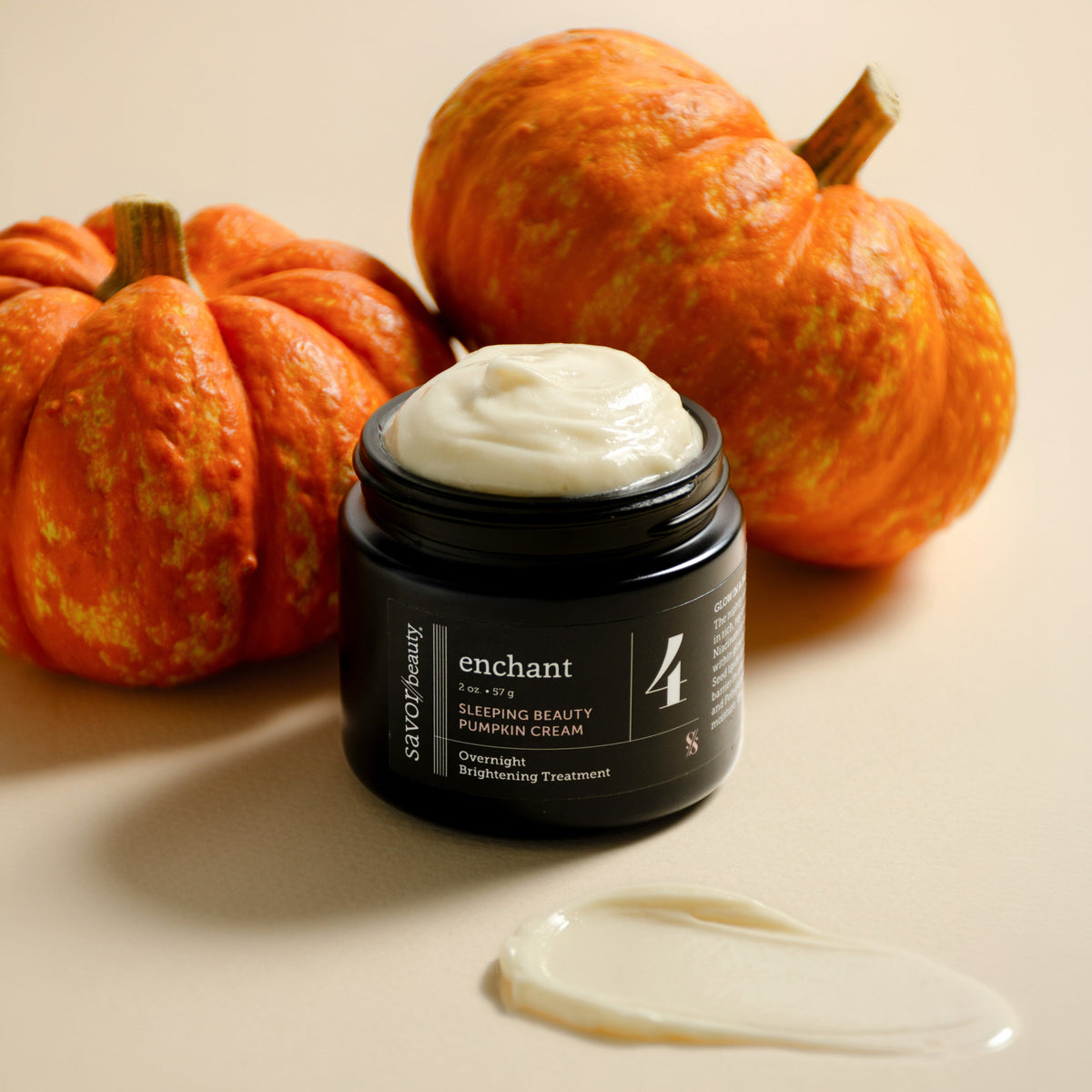 Savor Beauty's Sleeping Beauty Pumpkin Face cream on a cream backround with 2 small pumpkins, no lid and whipped cream texture on jar, 