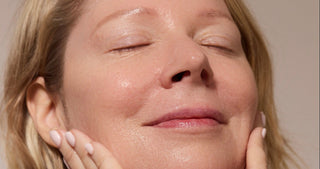 Woman with her eyes closed, washing her face