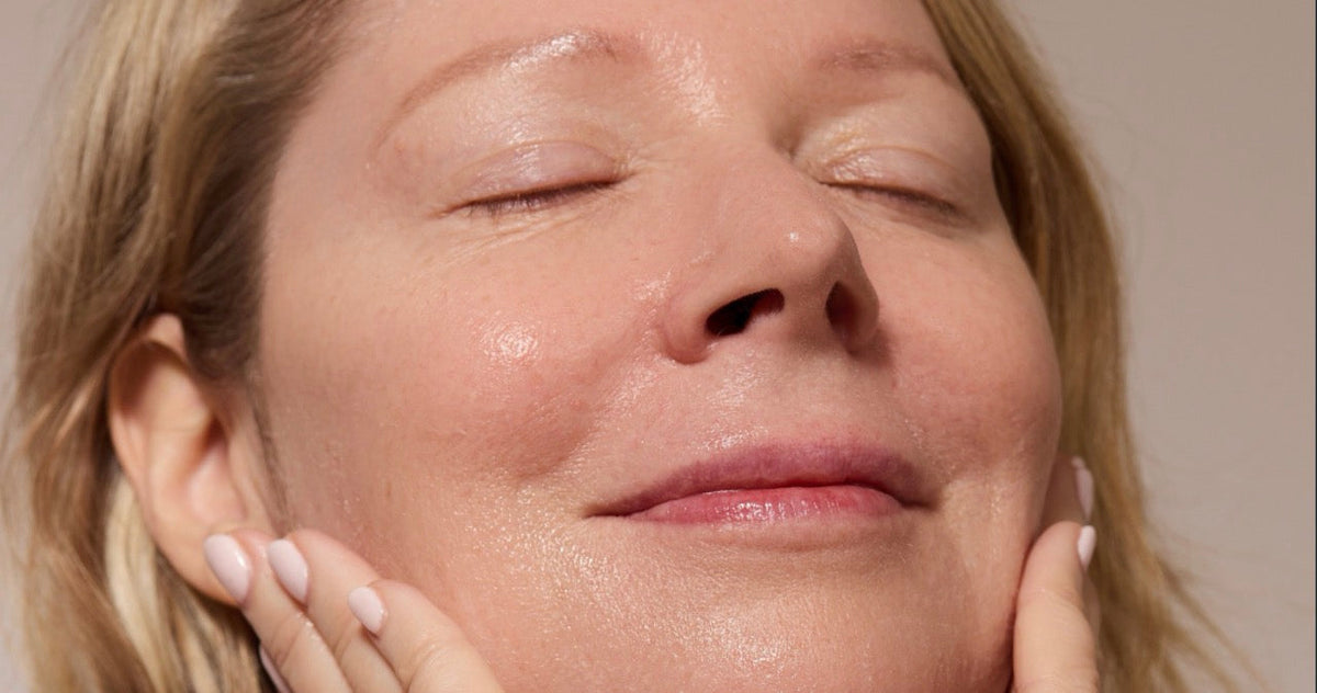Woman with her eyes closed, washing her face
