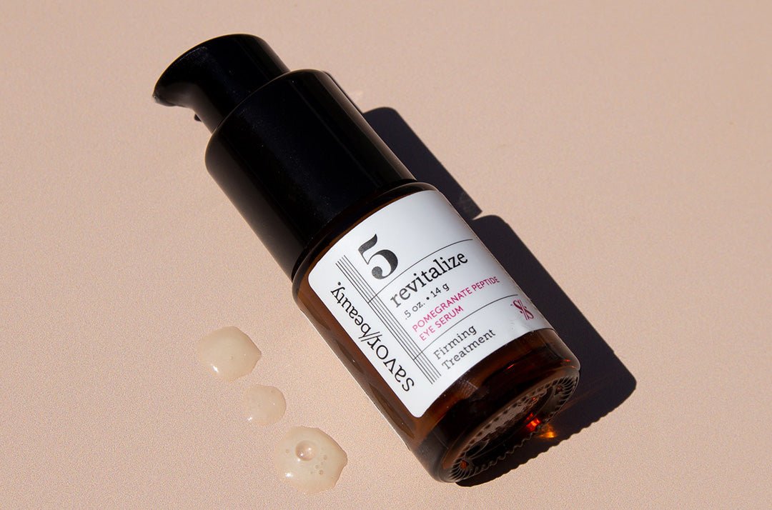 Close up shot of Pomegranate Eye Serum bottle and 3 drops of the product on a beige backround 
