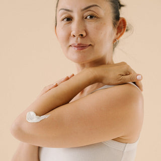 Woman with swatch of Chardonnay Body Cream on her arm