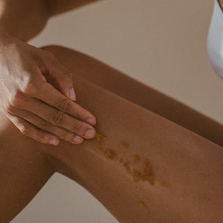 Applying non toxic Manuka Honey Sugar Scrub to leg