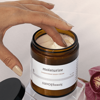 Finger in jar of Chardonnay Body Cream
