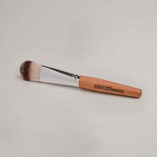 Mask brush with wooden handle reading 'Savor Beauty'