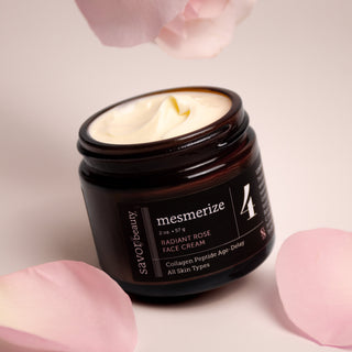 Jar of mesmerize skincare cream with a pink rose and petals on a light background